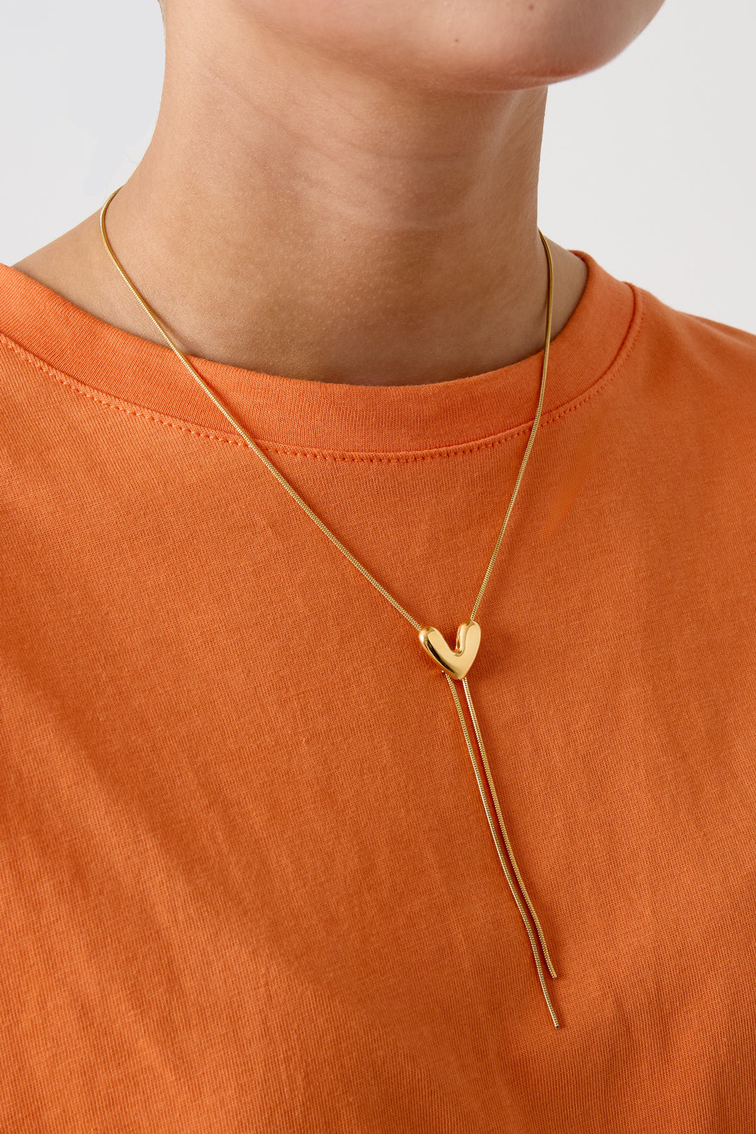 Goudkleurige premium stainless steel Y-ketting met hartje hanger gedragen om de hals