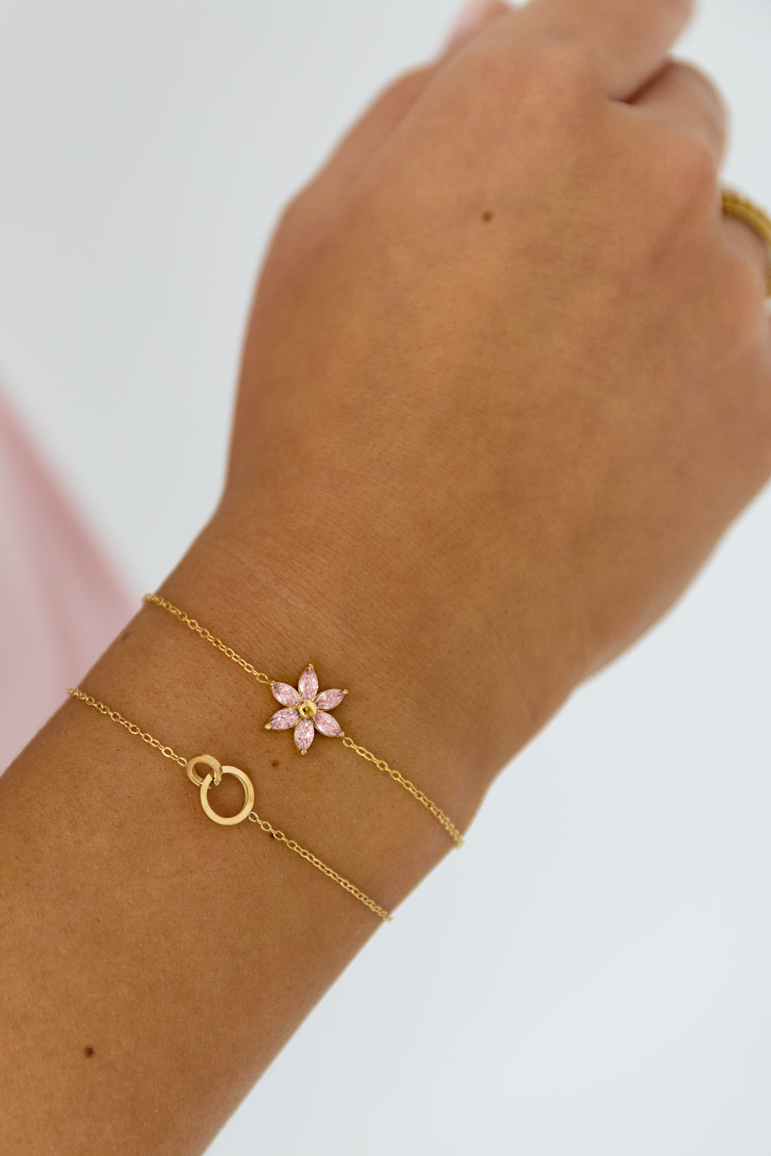 Minimalistische gouden armband gecombineerd met andere sieraden